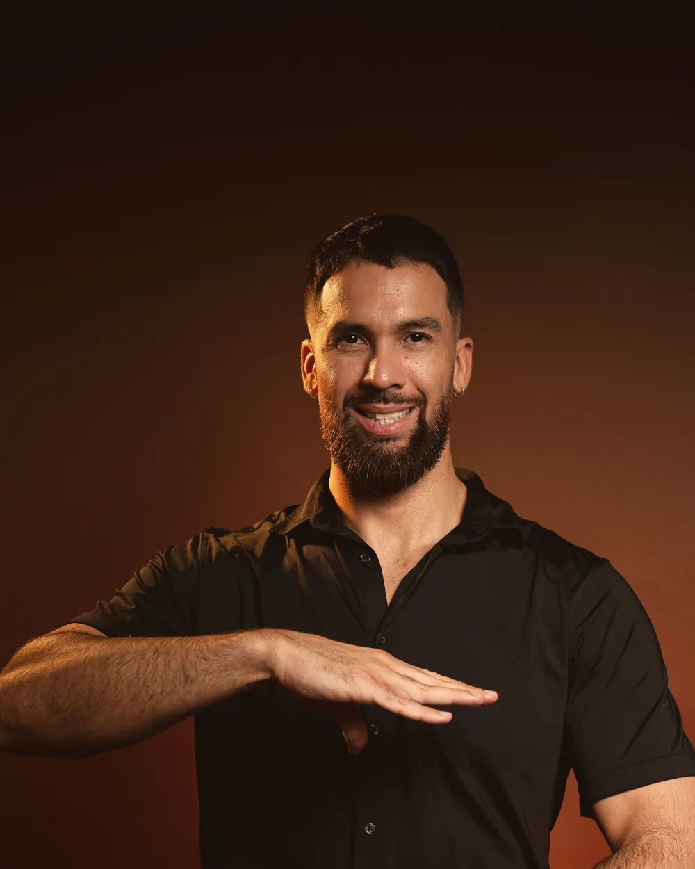 Jordan, fondateur de Magic Hands School, fait le geste des deux mains du logo